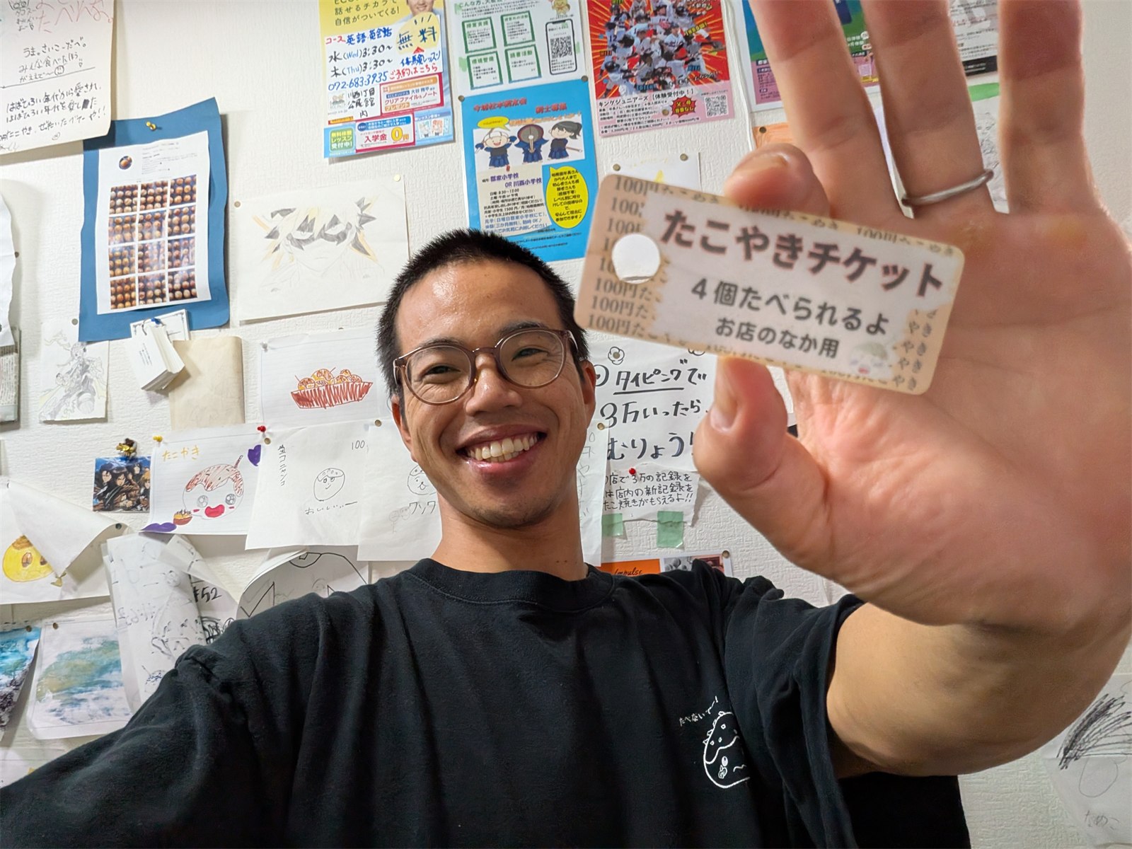 たこやきチケットを手に笑う、たこやき先生