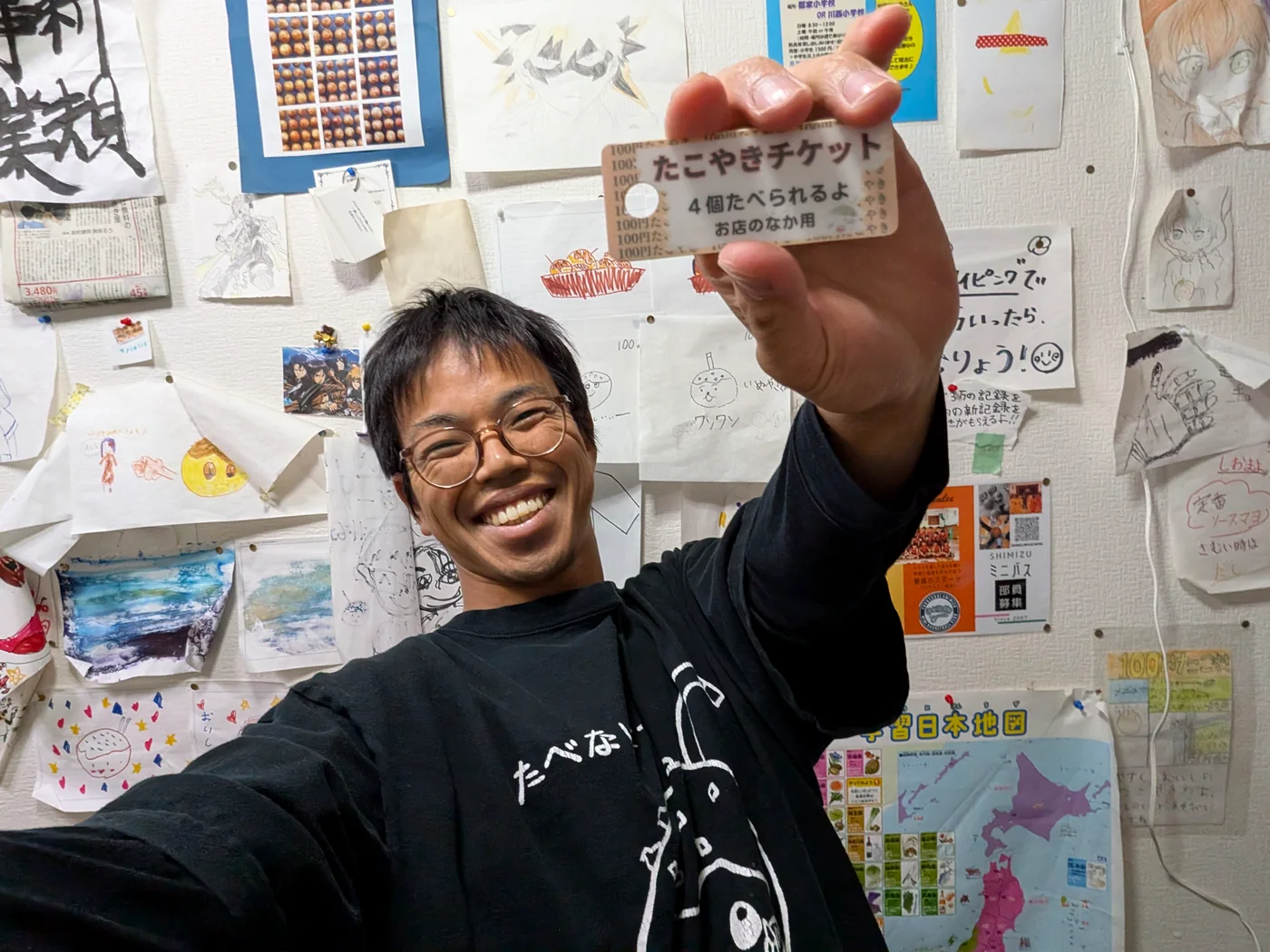 たこやきチケットを持って笑うたこやき先生